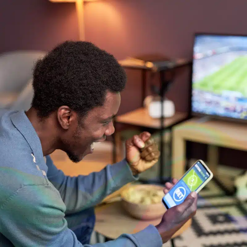 man with mobile phone watching online sport