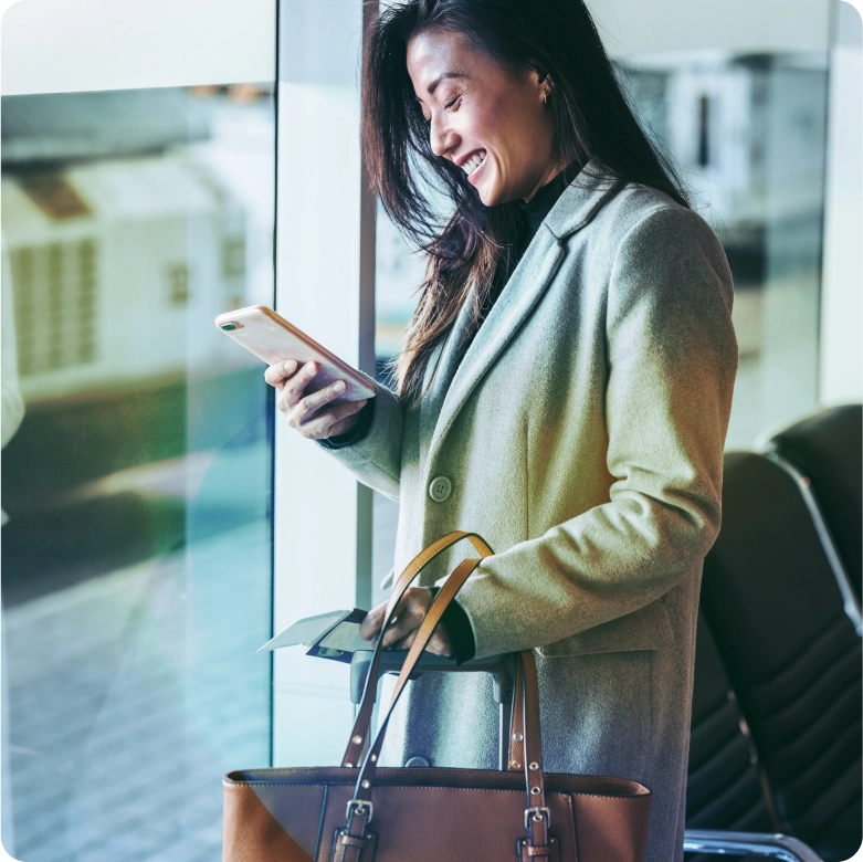 Woman traveling in the airport holding mobile with eWallet